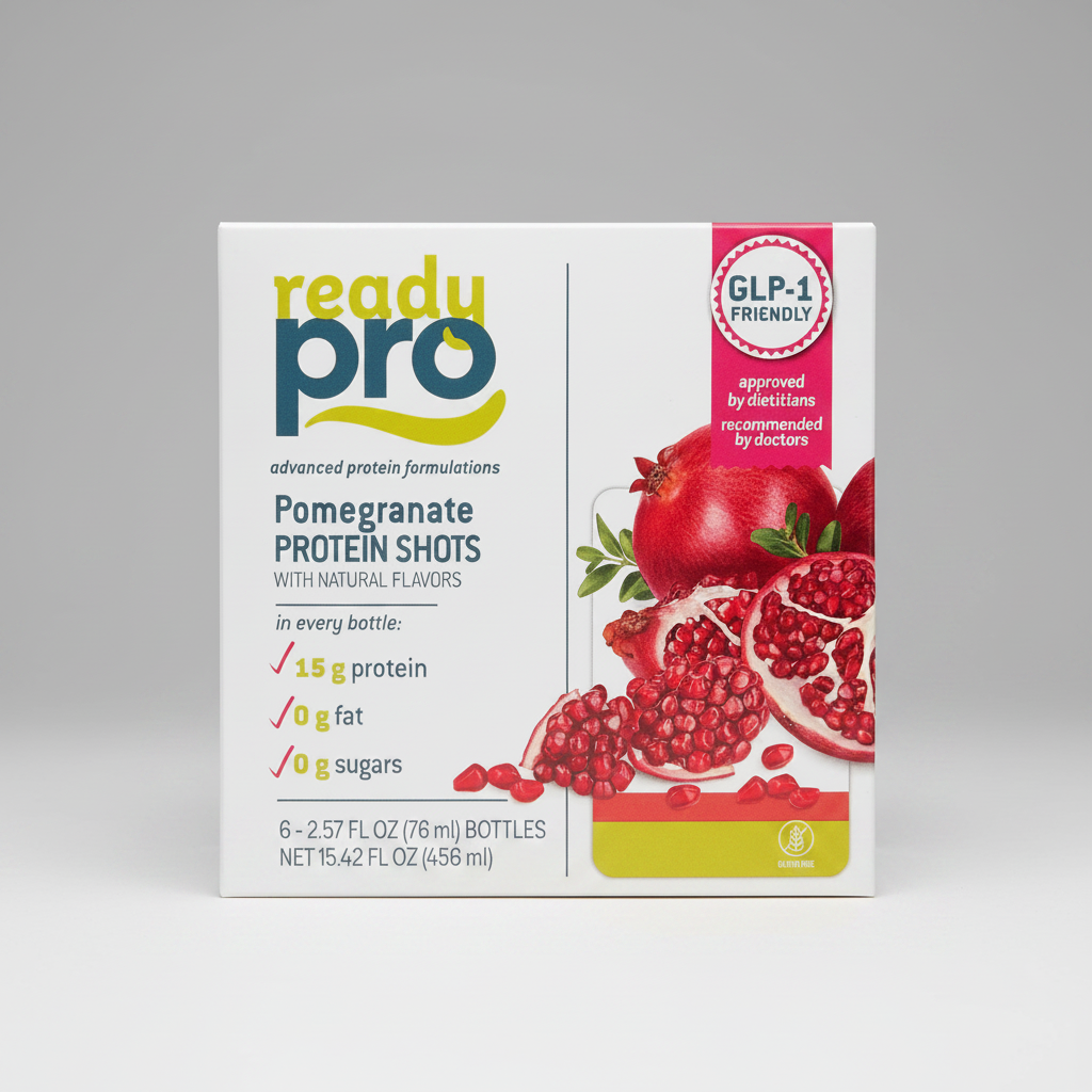 A box of Ready Pro Pomegranate Protein Shots, featuring a white background with a pink and green logo, product details, and a graphic of fresh pomegranates on the right side.